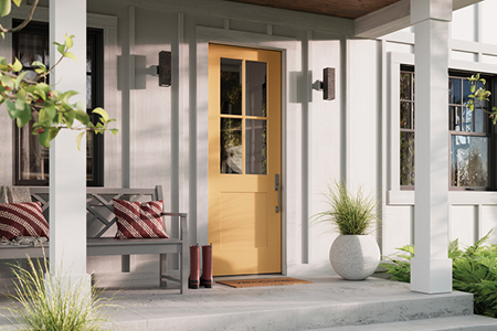 an exterior image of a white house with a front porch supported by columns and yellow entry door 