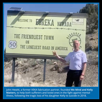 founder of We Mind and Kelly Matters next to Loneliest Road sign